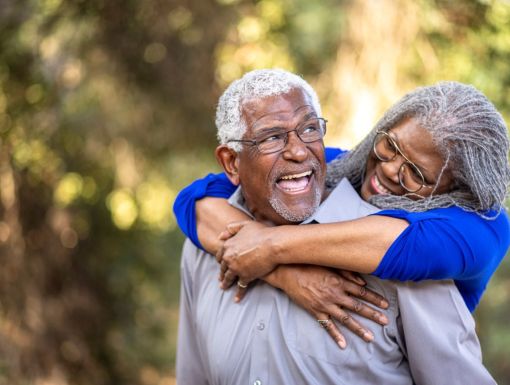 Mature couple piggyback in park
