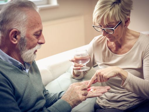 man with high blood pressure taking medicine given by his wife