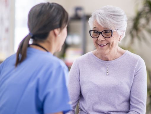 Happy Elderly Woman Talking with Healthcare Provider
