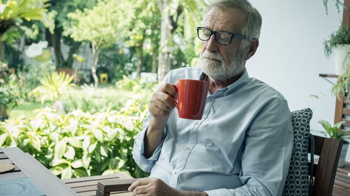 senior man sitting and holding cup of coffee