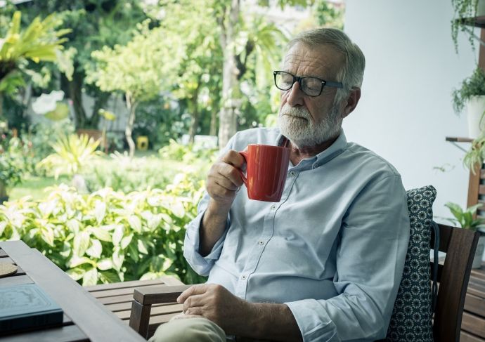 senior man sitting and holding cup of coffee