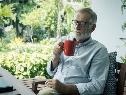 senior man sitting and holding cup of coffee