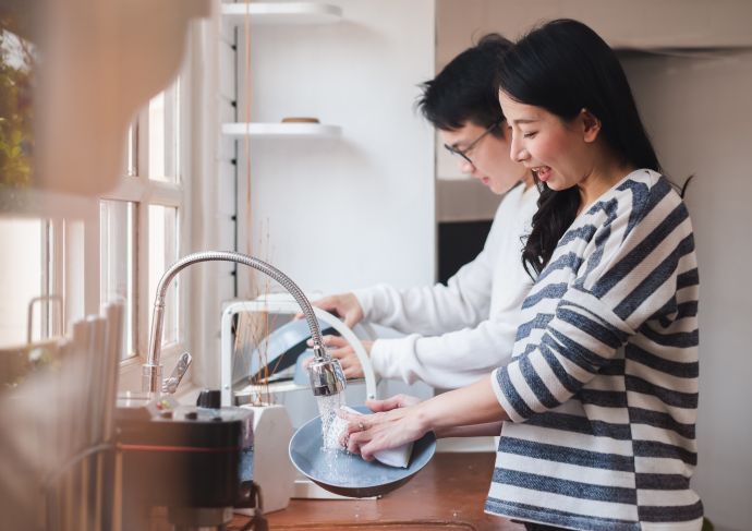 Couple cleaning dishes