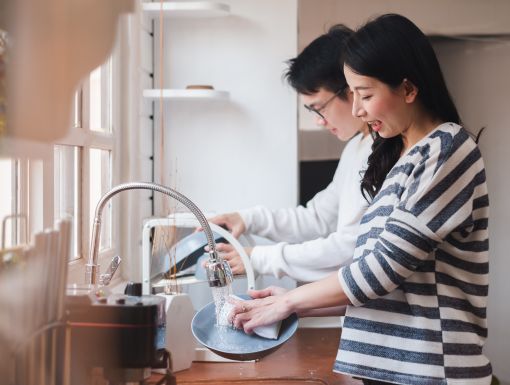 Couple cleaning dishes