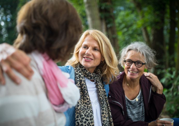 three older women hugging outside