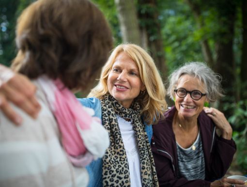 three older women hugging outside