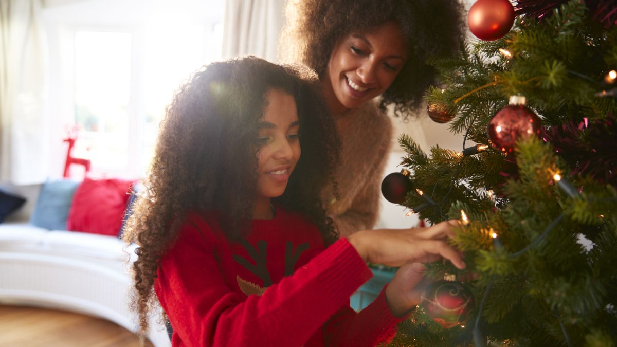 mother and daughter decorating Christmas tree