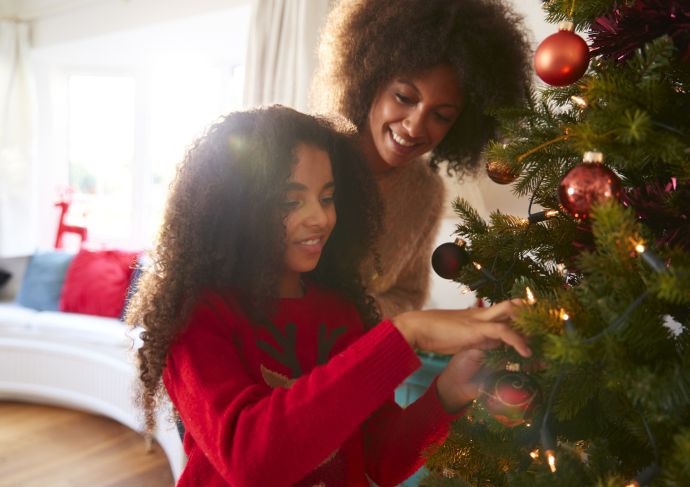 mother and daughter decorating Christmas tree