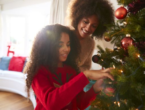 mother and daughter decorating Christmas tree