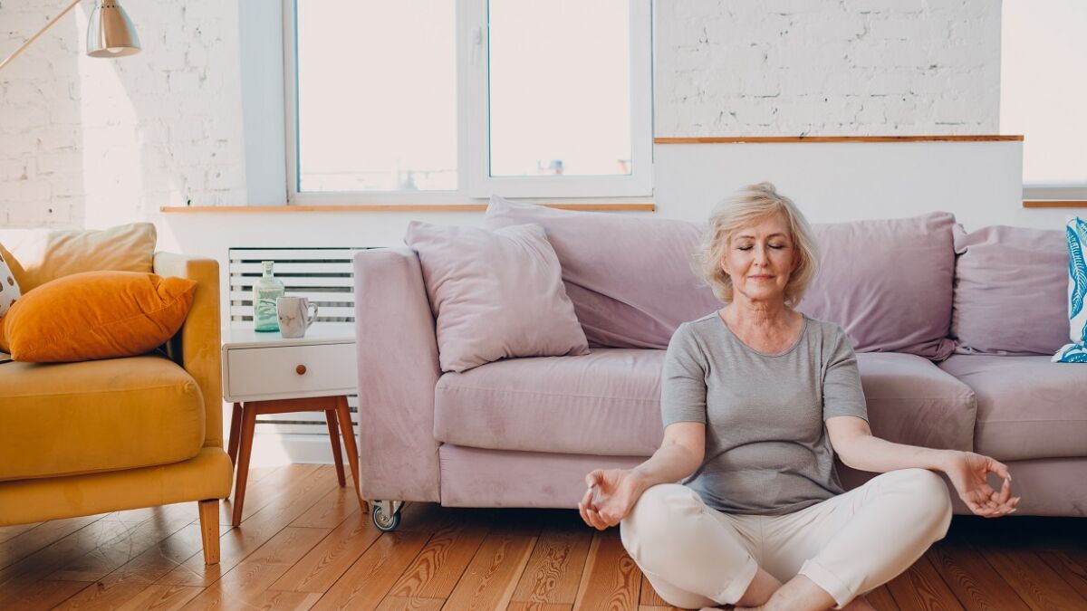 woman meditating on floor in living room