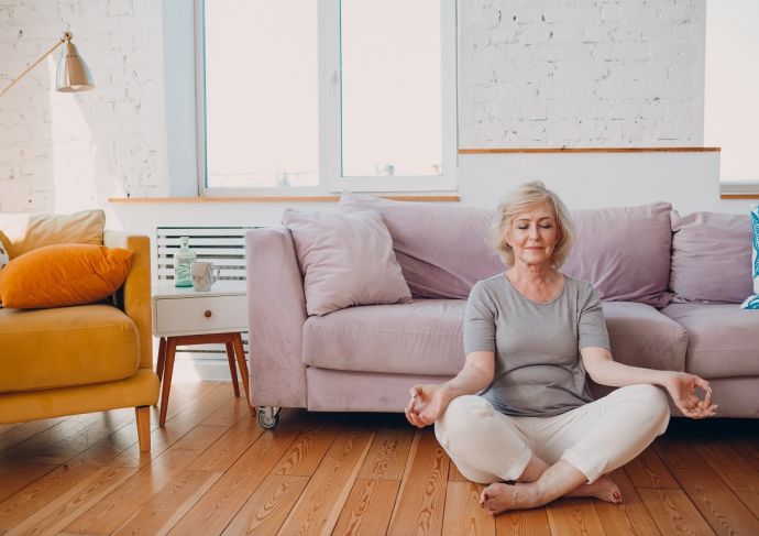 woman meditating on floor in living room