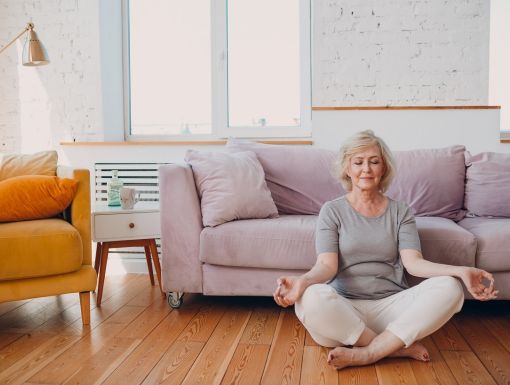 woman meditating on floor in living room