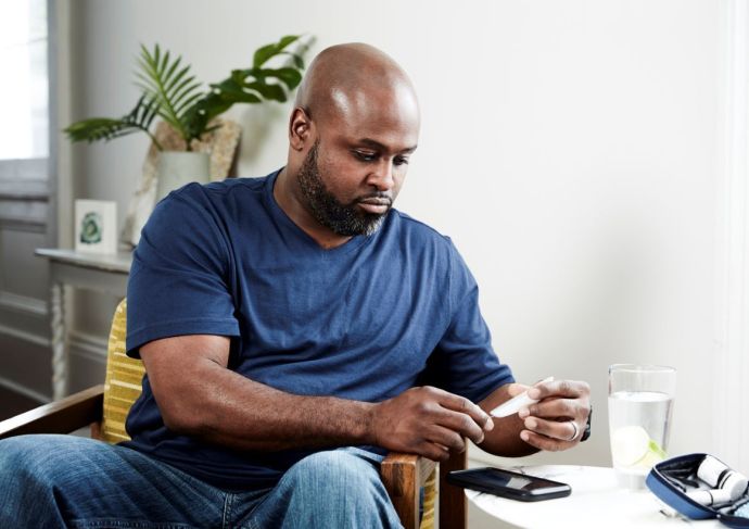seated-man-checking-blood-sugar-at-home