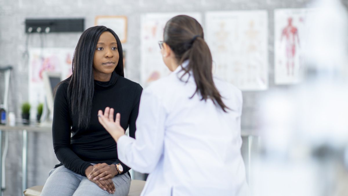 woman sitting on exam table talking to doctor