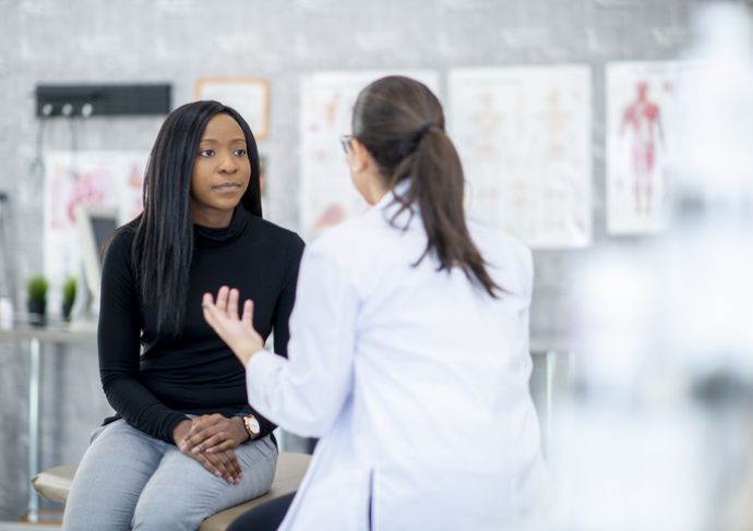 woman sitting on exam table talking to doctor