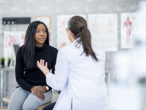 woman sitting on exam table talking to doctor