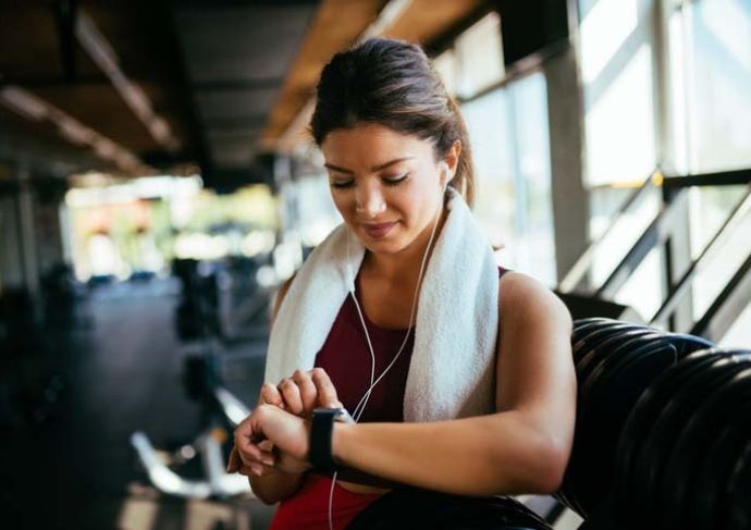 woman checking fitness watch at gym