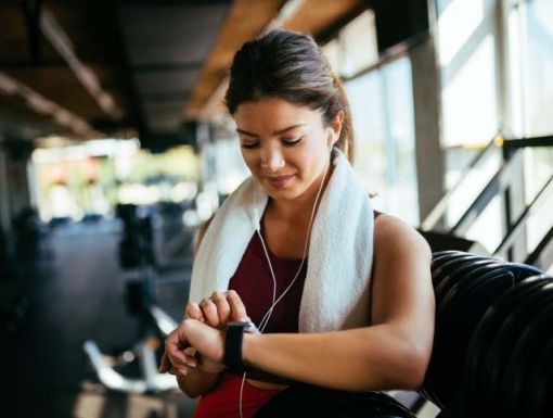 woman checking fitness watch at gym