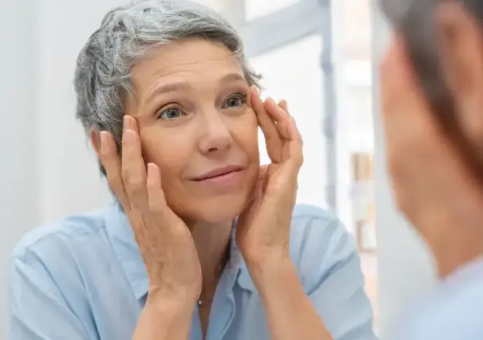 older woman looking in mirror