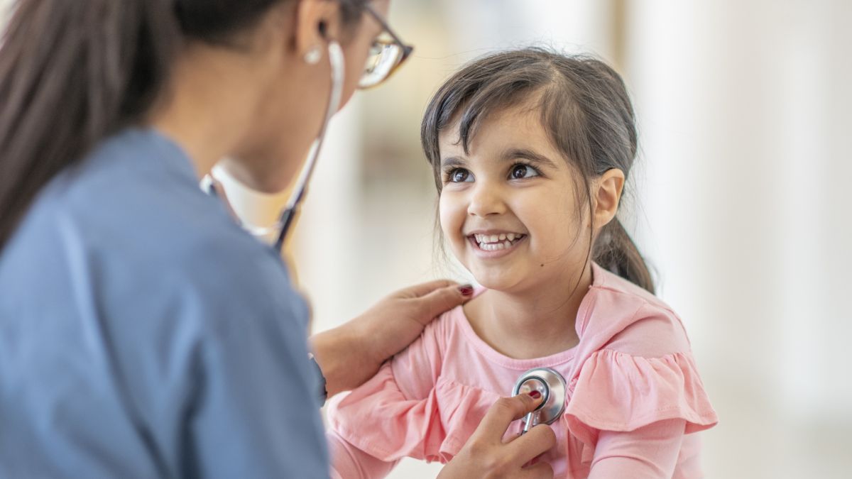 Doctor listening to young patient's heart