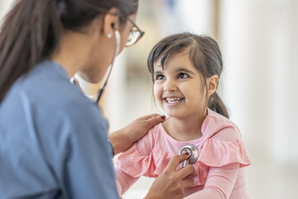 Doctor listening to young patient's heart