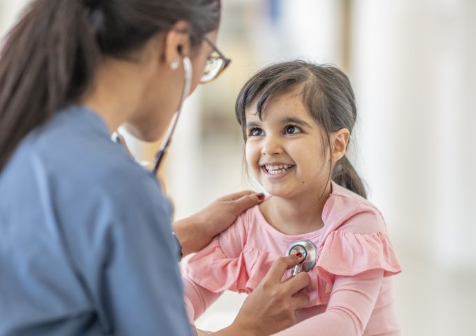 Doctor listening to young patient's heart