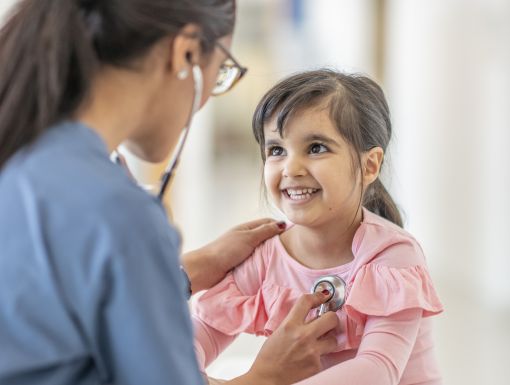 Doctor listening to young patient's heart