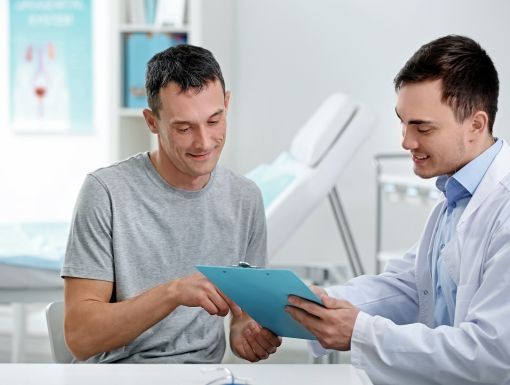 male patient and doctor speaking in exam room