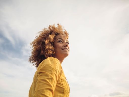 Woman looking into distance against cloudy sky