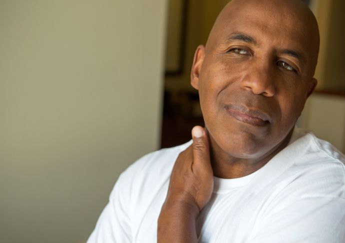 Man with chronic pain rubbing his neck