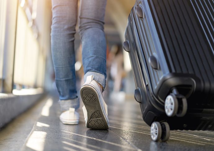 Person pulling wheeled suitcase