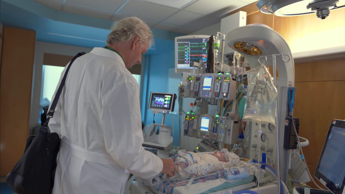 Cardiac surgeon looking at infant