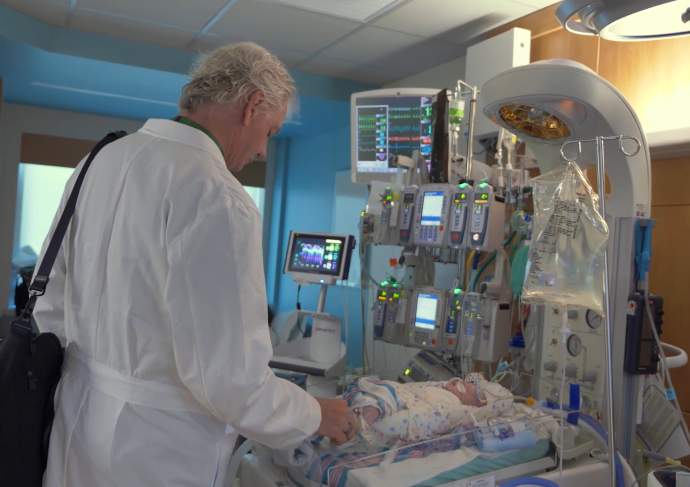 Cardiac surgeon looking at infant