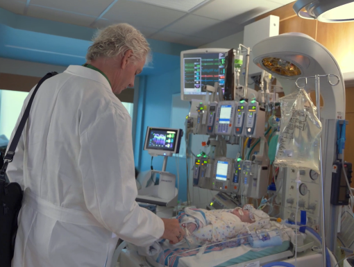Cardiac surgeon looking at infant