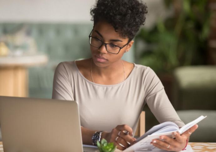 Women Looking at Computer writing notes 1