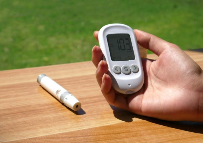 Woman holding device to check blood sugar