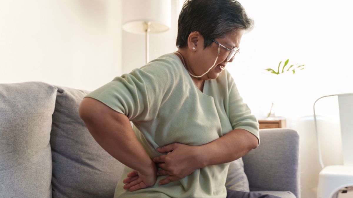 Mature woman with kidney pain holding side