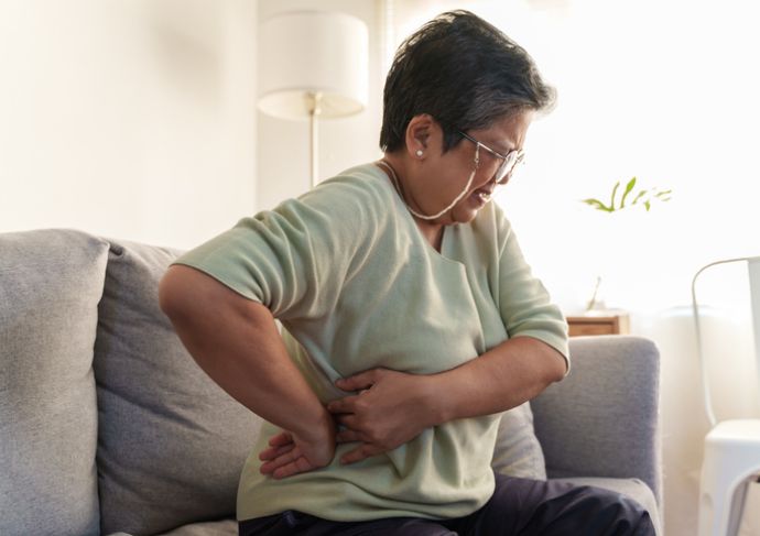 Mature woman with kidney pain holding side