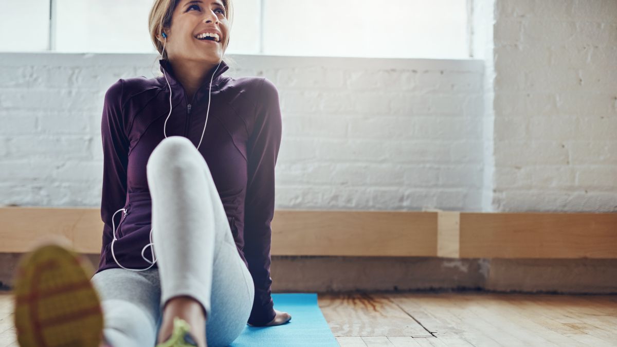 Woman sitting on a yoga mat exercising.