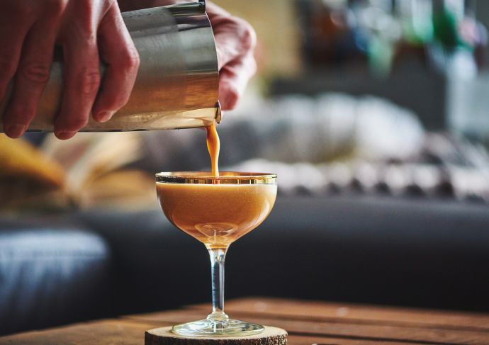 Hands pouring Billows and Theives zero proof cocktail
