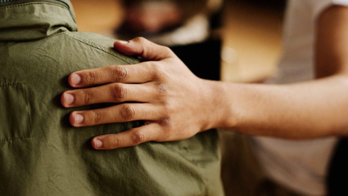 Hand on persons shoulder