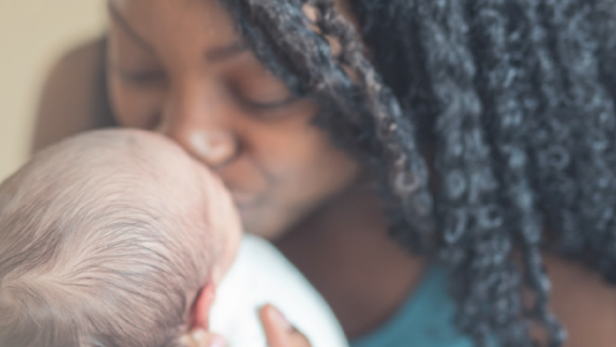 Mother kissing newborn babys head