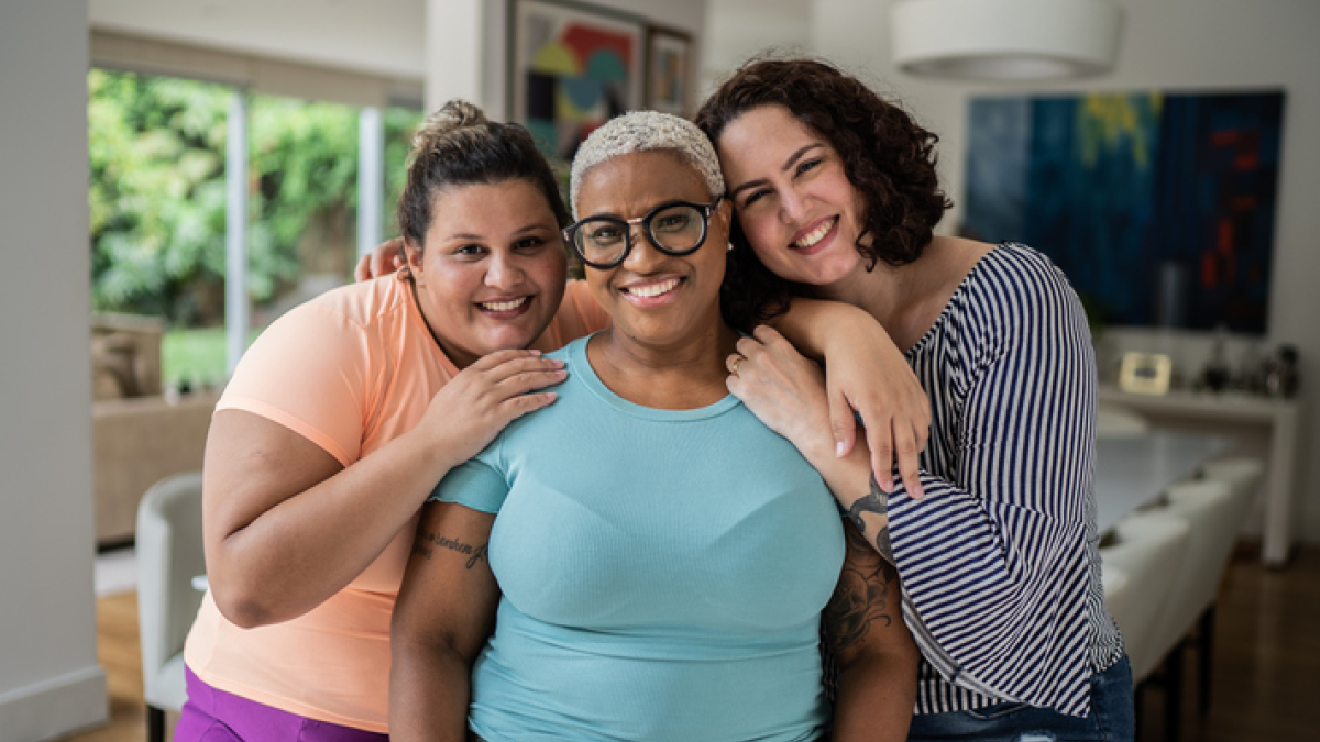 Three women hugging and smiling