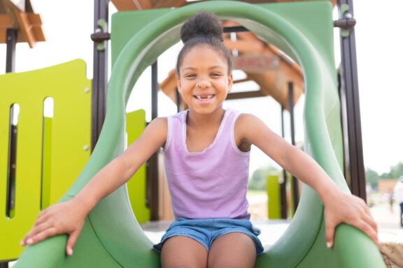 Little girl playing on slide