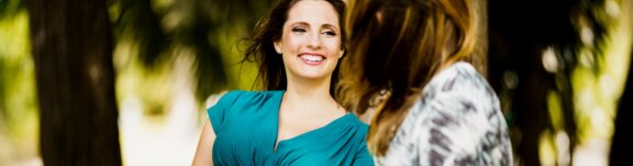Pregnant woman smiling talking with a friend