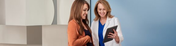 Doctor showing tablet to pregnant patient