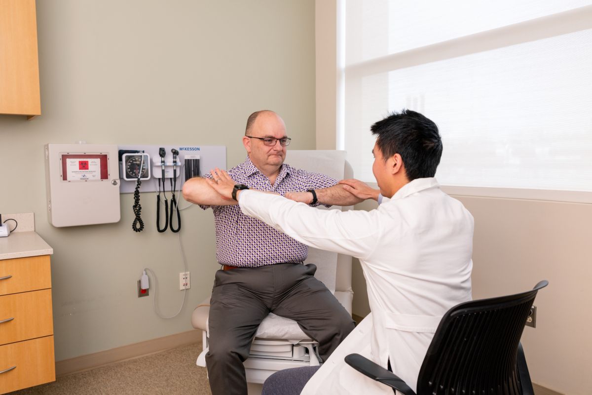 doctor helping patient in exam room