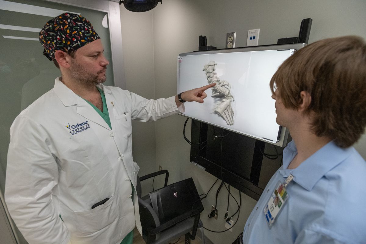 doctor looking at model of spine on screen