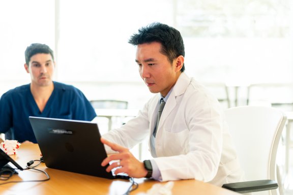 two doctors looking at notes on computer