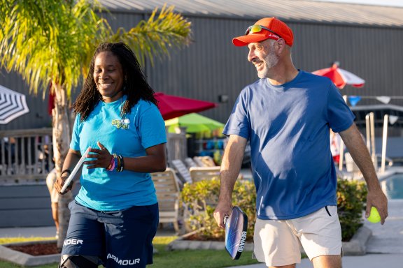 Man and woman playing pickleball outside